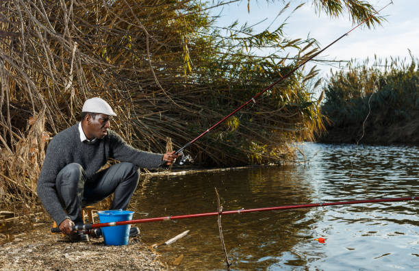 istock Fisherman sitting on wooden stool 1299059255