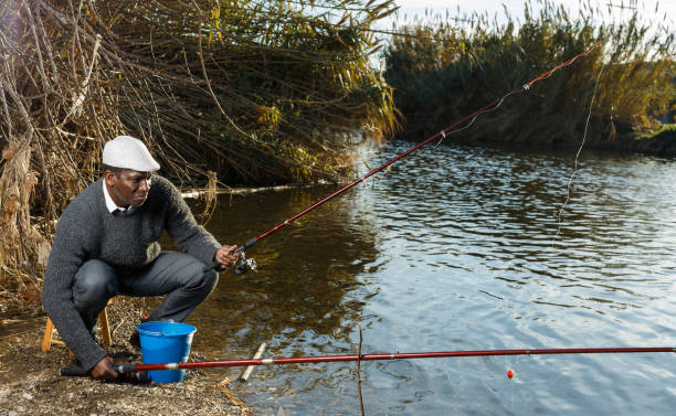 istock Man fishing with rods on river 1299059269