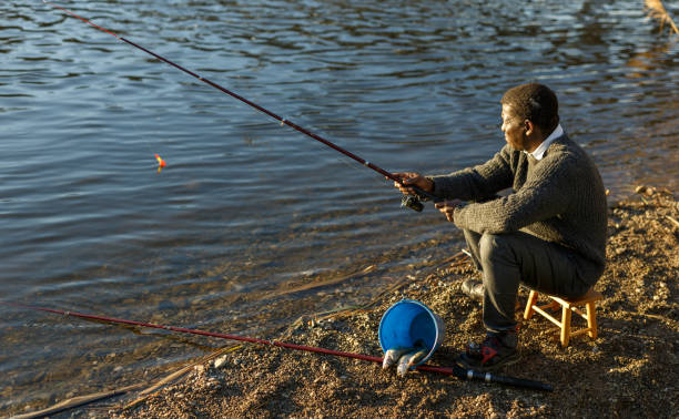 istock Fisherman sitting on wooden stool 1299059324