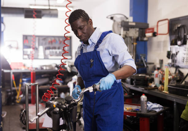 istock Service engineer repairs a motorcycle steering wheel in a motorcycle service 1299059893