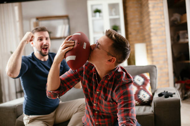 istock Men drinking beer and watching sports game on tv. 1299061002