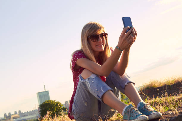 istock Young woman using modern smartphone outdoors. 1299062321