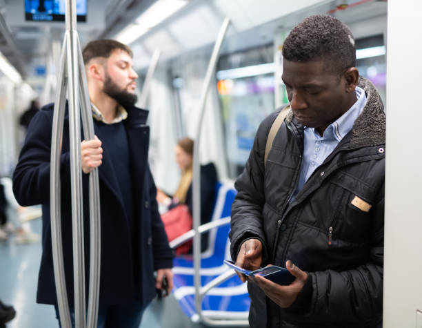 istock African man with phone in subway car 1299062876