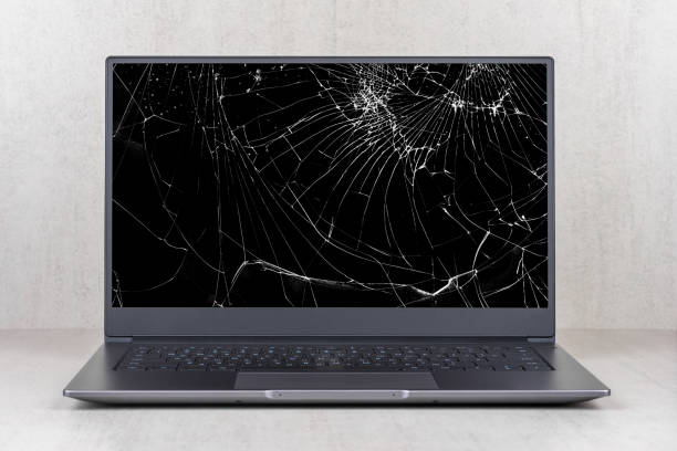 laptop with a broken screen in cracks on a gray background close up front view laptop with a broken screen in cracks on a gray background close up front view broken stock pictures, royalty-free photos & images