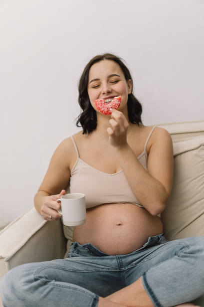 istock Pregnant woman enjoying donuts and tea. 1299065526