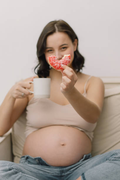 istock Pregnant woman enjoying donuts and tea. 1299065558