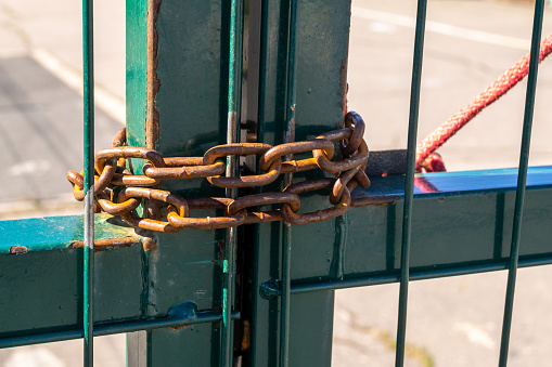 Metal gates closed by an old rusty chain. High quality photo