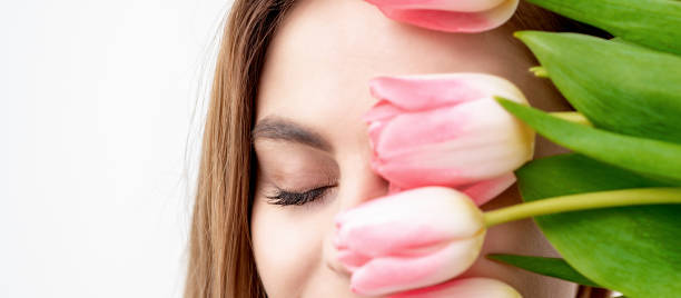 istock Young woman with pink tulips 1299066690