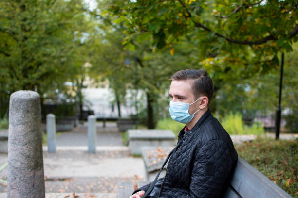 istock young adult guy sitting on a park bench 1299066809