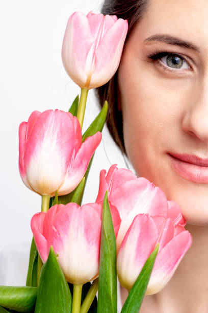 istock Young woman with pink tulips 1299066859