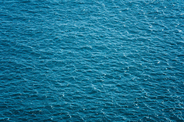 istock Blue turquoise surface of sea wave from above view background. 1299071748