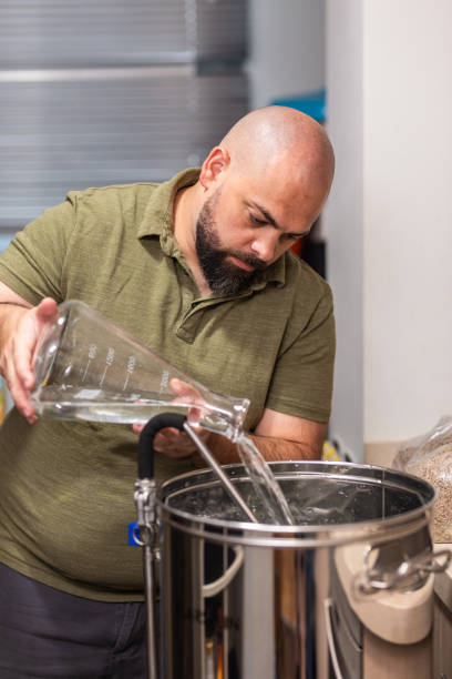 istock a man fills the kettle with water to make beer 1299071914