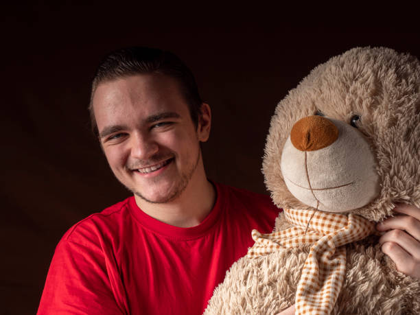 istock Young guy in a red t-shirt looks at camera 1299072261