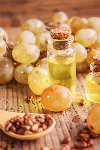 istock Grape seed oil in glass jar on wooden background. Selective focus 1299073251