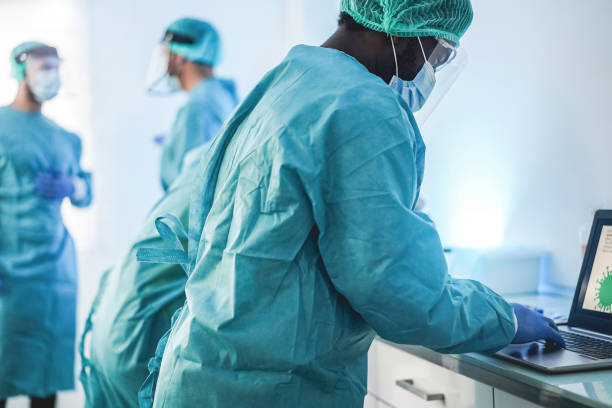 istock Medical workers in hazmat suit working with computer laptop  inside hospital lab during coronavirus outbreak 1299074690
