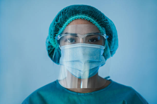 코로나바이러스 기간 동안 병원 내부에서 일하는 젊은 여성 간호사의 초상화 - 얼굴 보호 마스크를 착용한 covid-19 발병에 여성 의료 종사자 - surgeon hospital surgery doctor 뉴스 사진 이미지