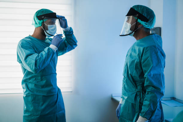 istock Surgeons preparing for surgical operation during coronavirus outbreak - Focus on right doctor head 1299074813