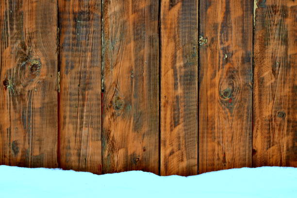 istock snow and a wall of dark wooden boards 1299074981