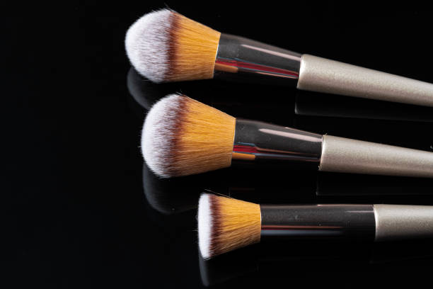 istock Collection of make up brushes on black background 1299075095