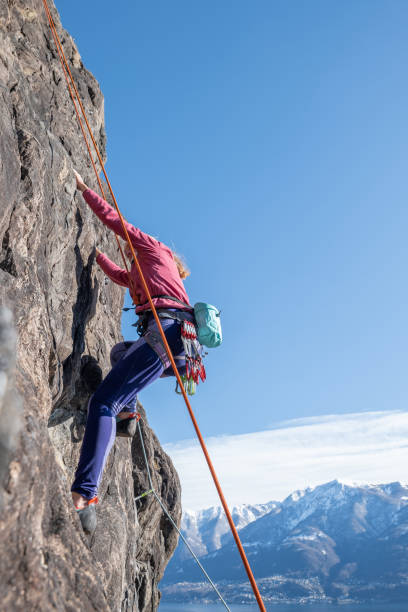 istock Female mountain climber ascend rock face 1299075627