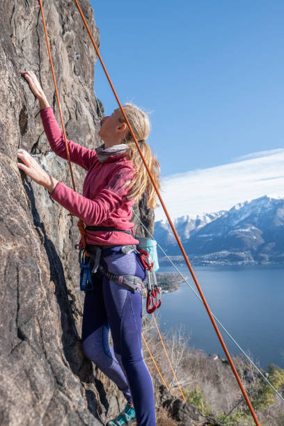 istock Female mountain climber ascend rock face 1299075733