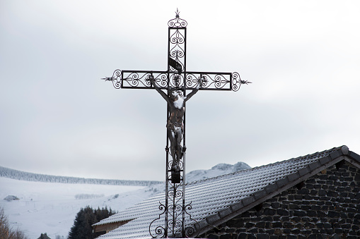 Cross and sculpture of Christ in the village square Les Estables in Haute Loire in France