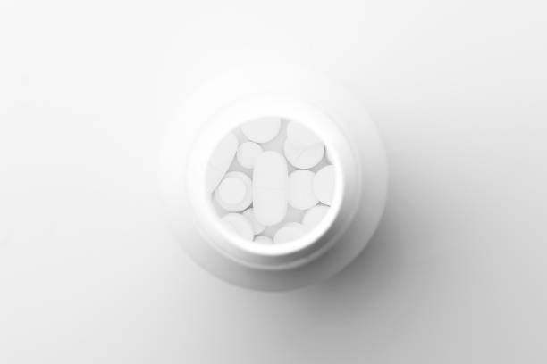 istock Bottle with white medicine pills on white background, with copy space. Flat lay, top view. Close up. Medical concept. 1299076323