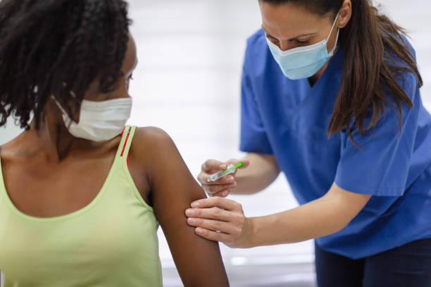 istock African-American female taking a COVID-19 vaccine 1299076517