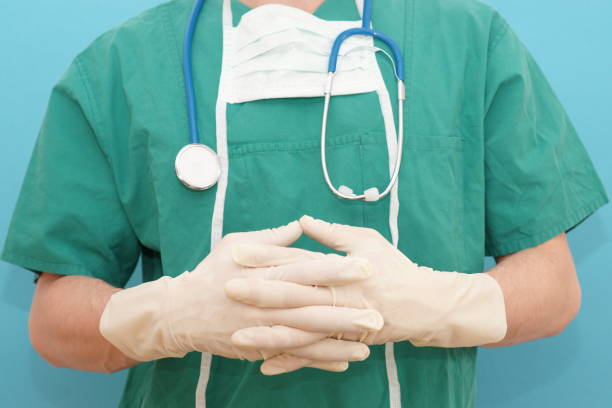 istock Surgeon explains operation method - doctor in op clothes and rubber gloves with explanation gesture 1299077289