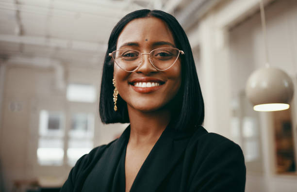 Positivity puts you in a position of power Portrait of a confident young businesswoman working in a modern office indian woman smiling stock pictures, royalty-free photos & images