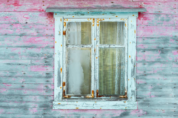 istock Peeling damaged paint on old wooden shed  colored background 1299077679
