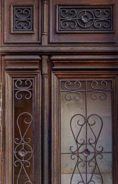istock Old brown wooden door with rustic forged wrought iron ornaments 1299078766