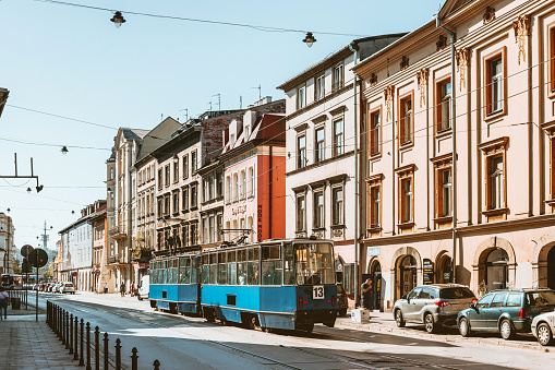 blue old tram passing in front of facades of old town Krakow