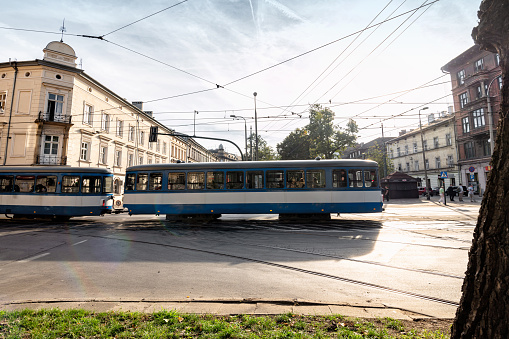 typical blue tram crossing intersection in Krakow at sunny late summer afternoon