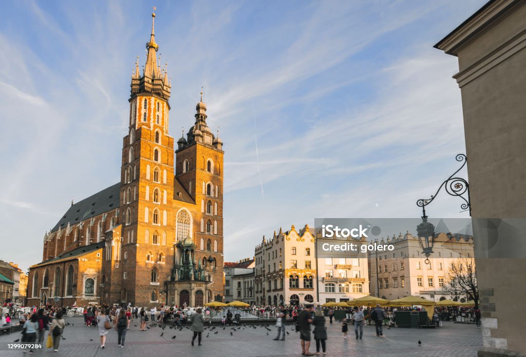 market place with saint mary´s church in Krakow, Poland visitors at the main market place with saint mary´s church in the background in Krakow, Poland Krakow Stock Photo