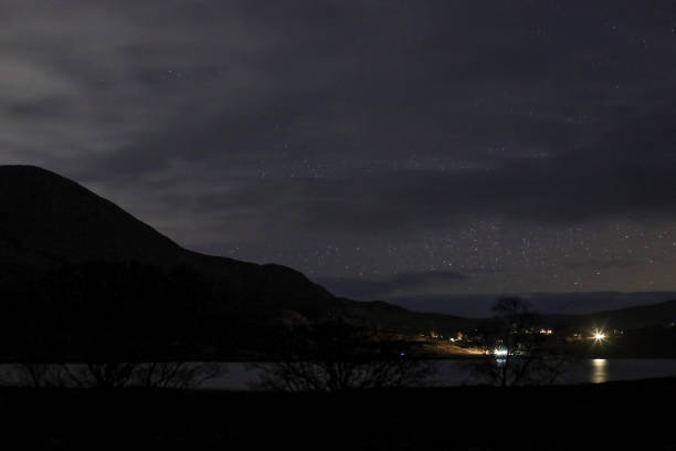 Night time stars over harbour on the Isle of Skye in Scotland