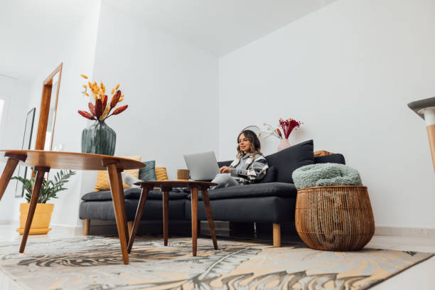 istock Woman relaxing on comfortable couch, using laptop at home. 1299080119