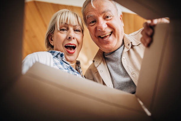 istock Senior couple unpacking cardboard box together 1299080326