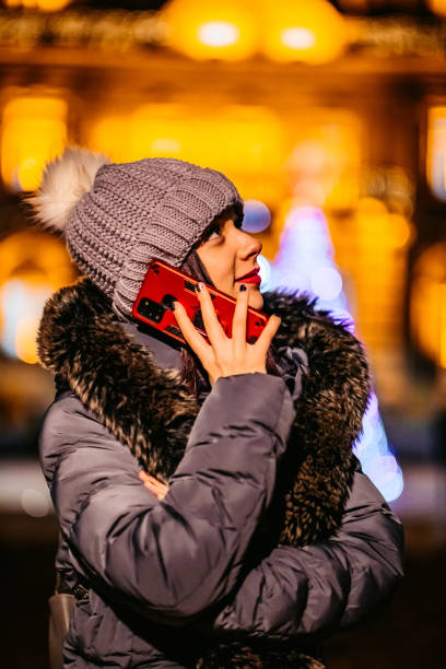 istock Woman talking on phone outdoors at Christmas time 1299080376