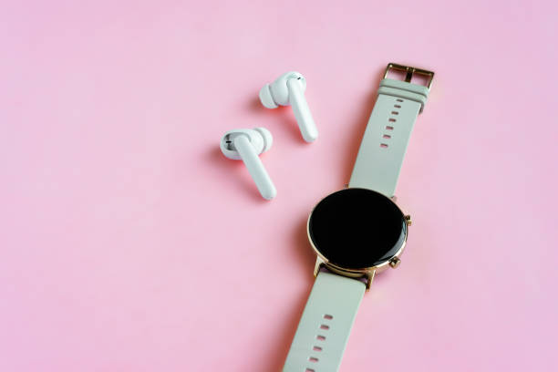 istock Wireless headphone and smartwatch on pink background 1299080377