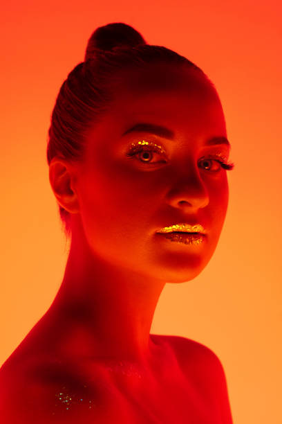istock Handsome woman's portrait isolated on orange gradient studio background in neon light, monochrome 1299081486