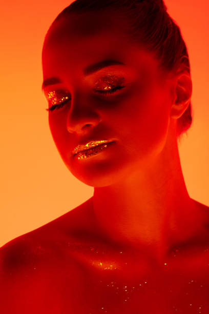 istock Handsome woman's portrait isolated on orange gradient studio background in neon light, monochrome 1299081502