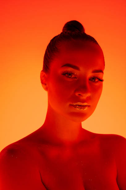 istock Handsome woman's portrait isolated on orange gradient studio background in neon light, monochrome 1299081513