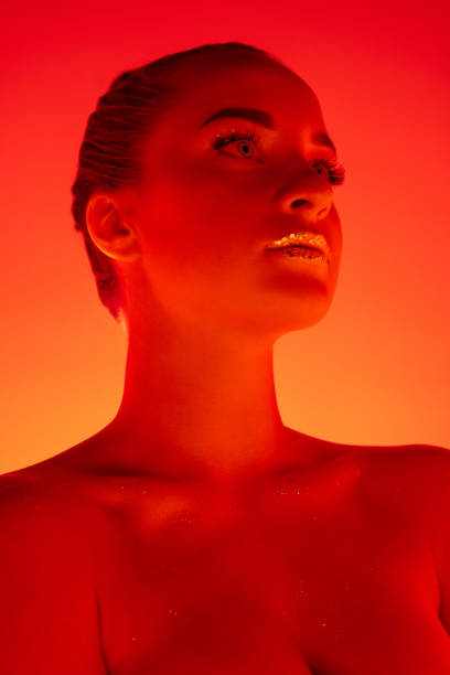 istock Handsome woman's portrait isolated on orange gradient studio background in neon light, monochrome 1299081515