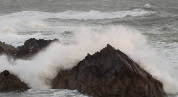 istock Rocks in stormy sea 1299083436