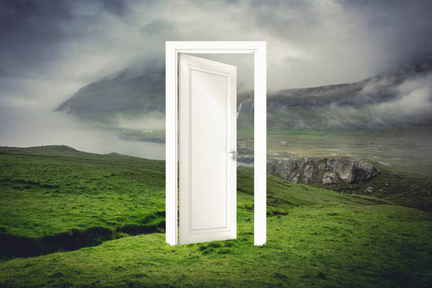 istock open white door in a natural landscape with sea and land. 1299084010