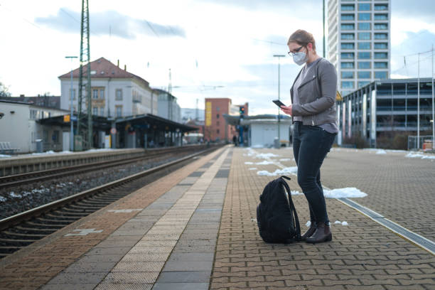 istock Woman waiting on the train station wearing protective mask 1299085339