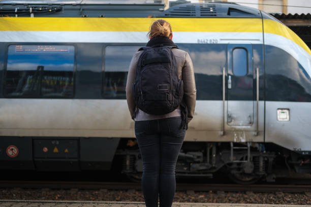 istock Young adult waiting on the train station wearing protective mask 1299085582