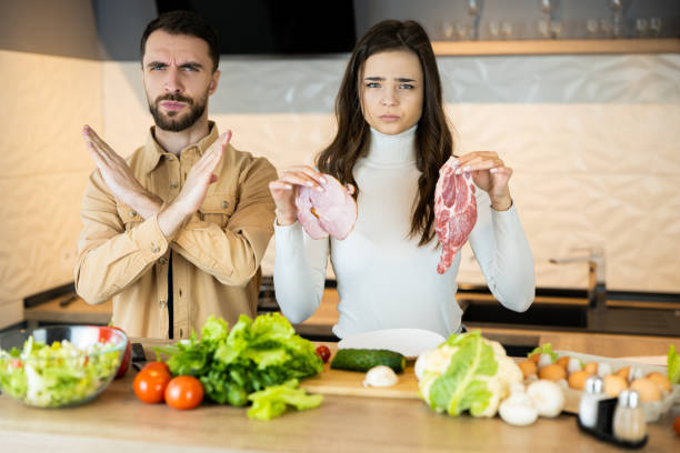 Young vegetarian couple is showing that they don't like eating meat and prefer fresh vegetables to it. Healthy lifestyle without meat Young vegetarian couple is showing that they don't like eating meat and prefer fresh vegetables to it. Healthy lifestyle without meat. dont eat meat stock pictures, royalty-free photos & images