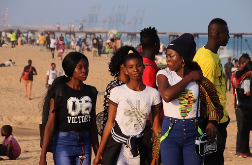 Lomé, Togo - June 30, 2019: Young women enjoy the beach of Lomé at the late afternoon.